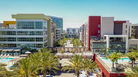 A modern building complex with a pool in the foreground.