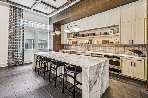 A kitchen with a marble island and wooden cabinets.