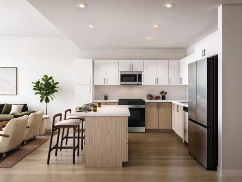 A modern kitchen with a refrigerator, oven, and sink.