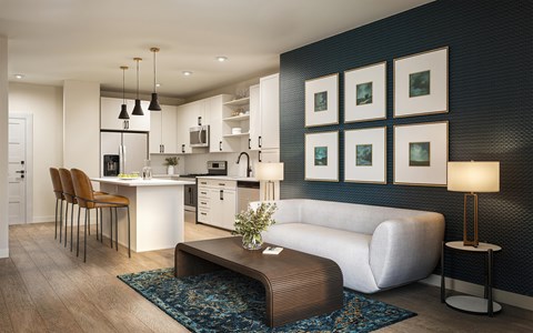 A modern kitchen with a white island and a white sofa.