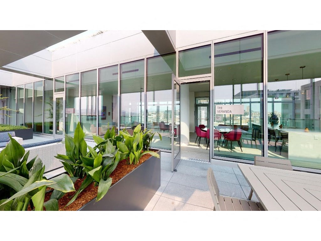 a large glass walled building with tables and chairs