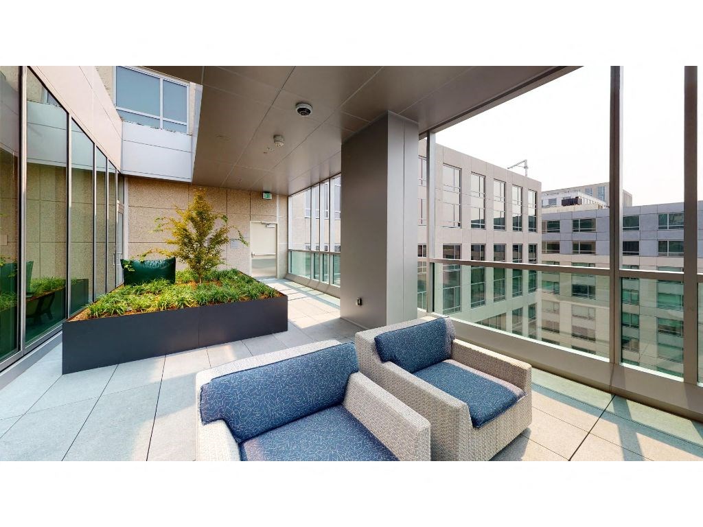 a seating area in the lobby of an office building with a pool in the background