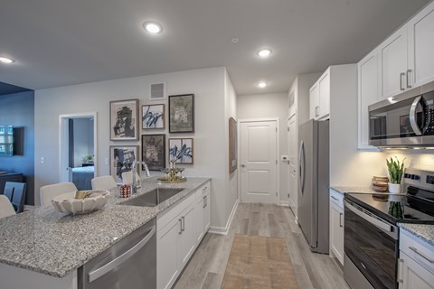 A kitchen with a granite countertop and stainless steel appliances.