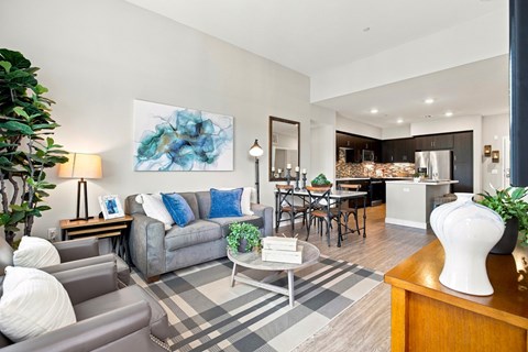 A living room with a grey couch and a blue pillow.