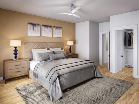A bedroom with a large bed and a ceiling fan.
