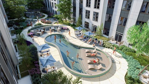 A large outdoor pool surrounded by trees and people sunbathing.