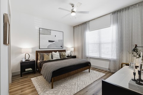 A bedroom with a large bed and a ceiling fan.