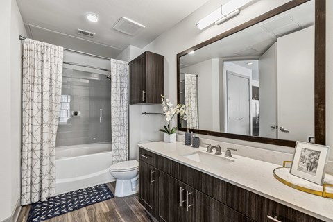 A bathroom with a white toilet, a sink, and a mirror.