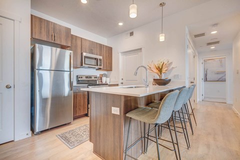 a kitchen with stainless steel appliances and an island with bar stools