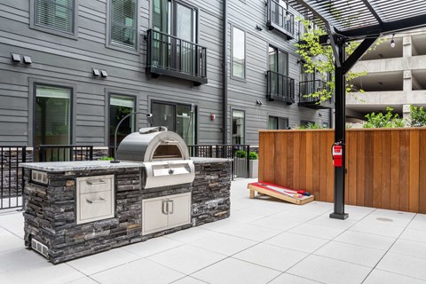 A modern outdoor kitchen area with a stone counter and a built-in oven.
