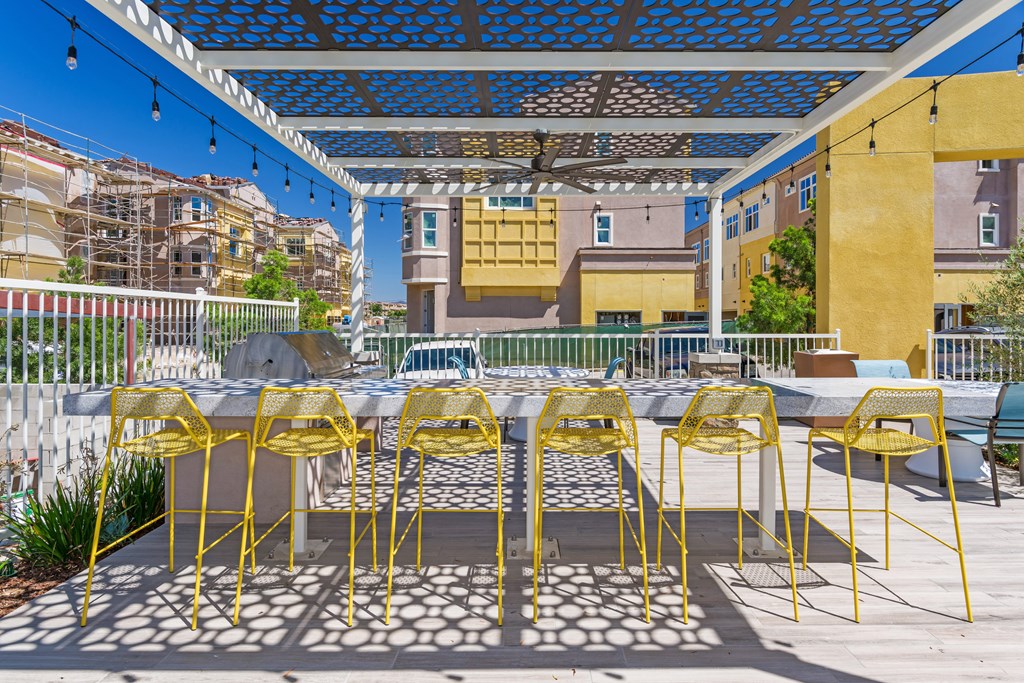 A patio with yellow chairs and a table.