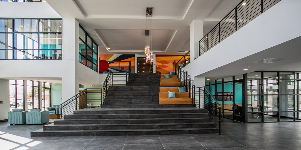 the lobby of a building with a large staircase and large windows