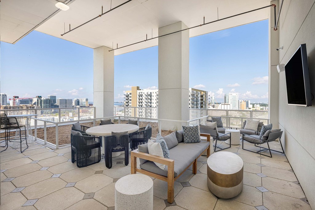 a balcony with tables and chairs and a view of the city