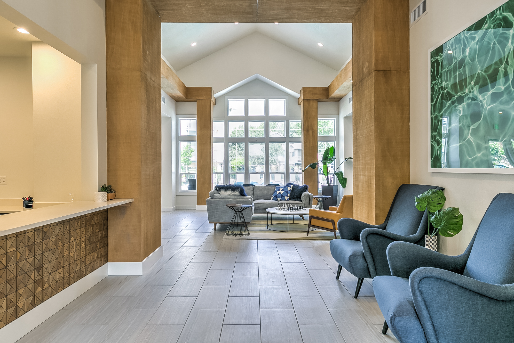 A living room with a grey sofa and a wooden floor.