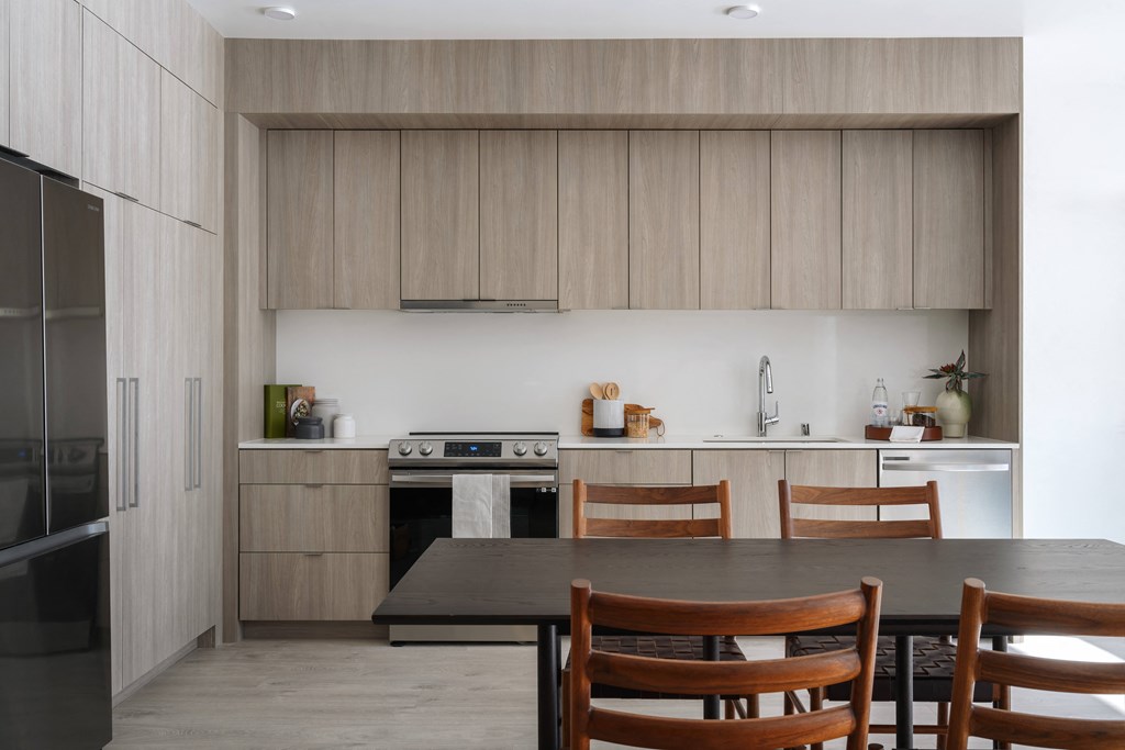 a kitchen with wooden cabinets and a table and chairs