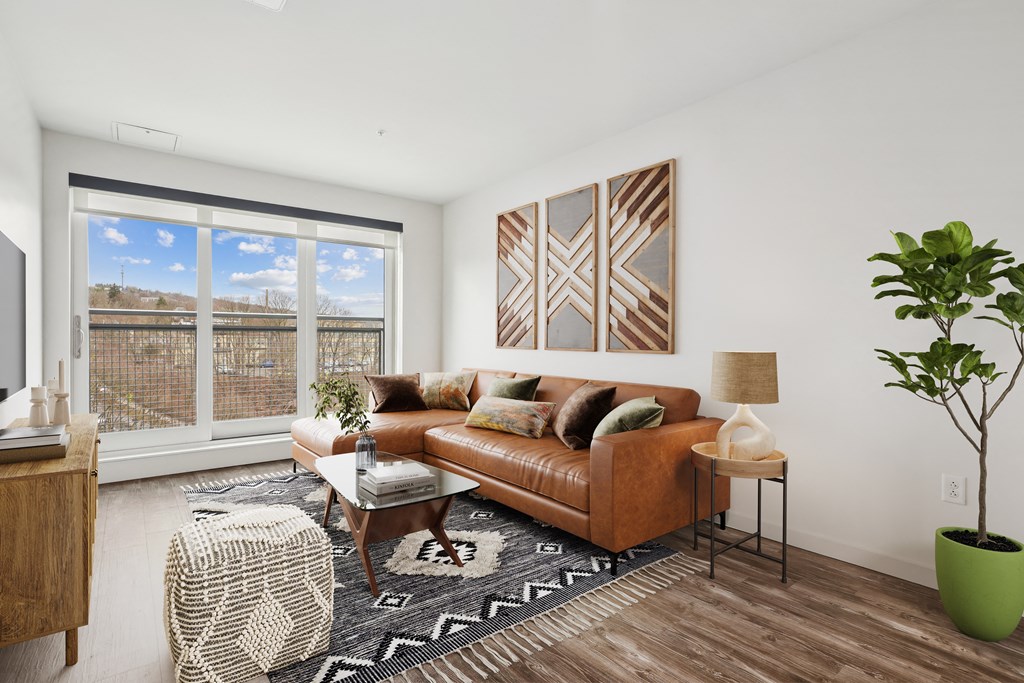 a living room with a leather couch and a large window