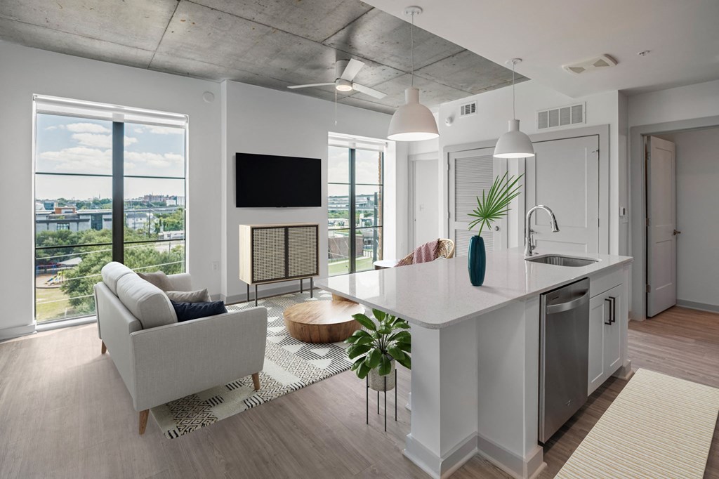 an open concept living room and kitchen with a large window and a view of the city