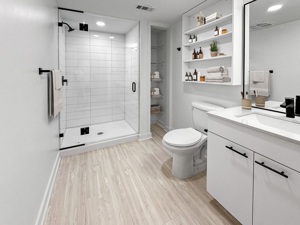 a white bathroom with a toilet and a shower