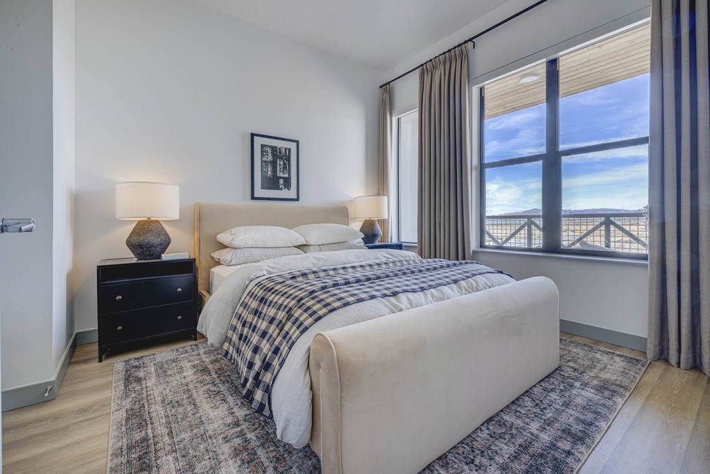 A bedroom with a large bed and a view of the ocean through the window.