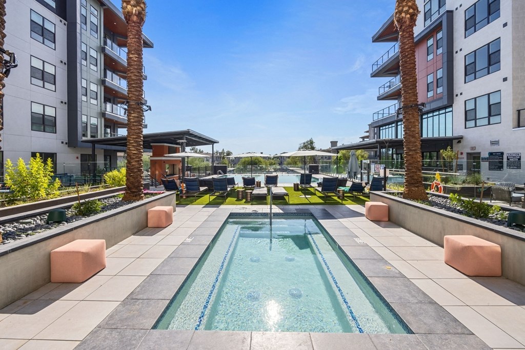 a swimming pool in the middle of an apartment building with palm trees