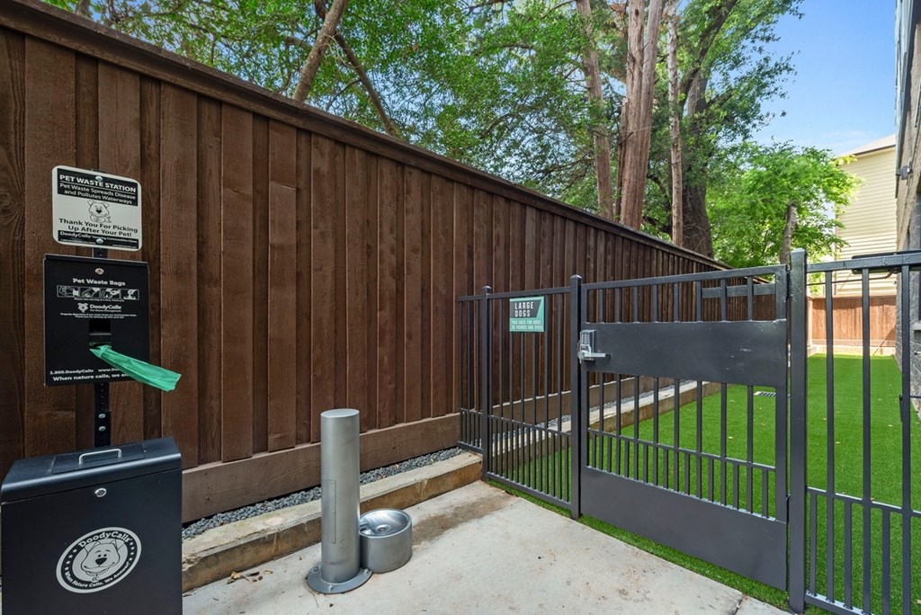 A black gate with a green arrow pointing to a black box with a white logo on it.