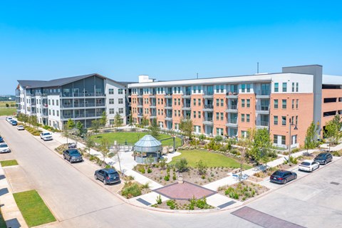 an aerial view of an apartment complex with cars parked in front of it