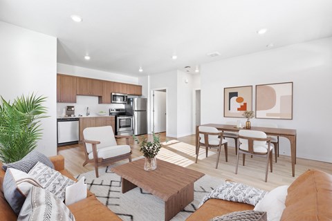 A modern living room with a dining area and kitchen in the background.