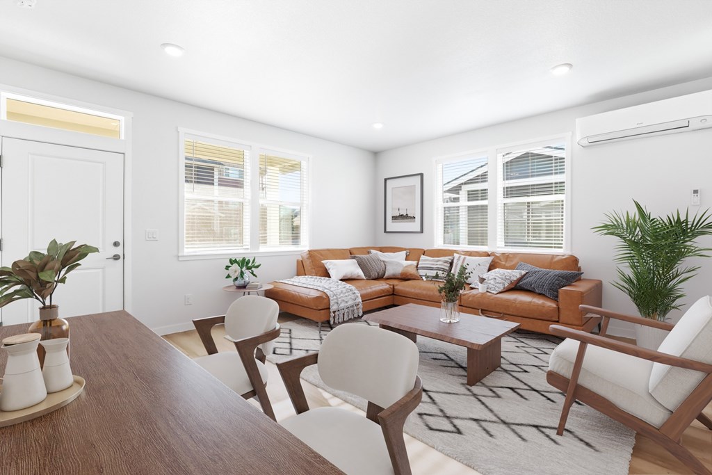A modern living room with a brown wooden table and white chairs.