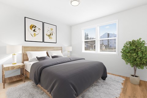 A bedroom with a large bed and two framed pictures on the wall.