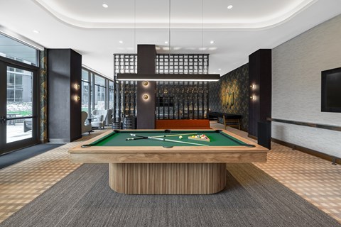 A pool table in a room with a black and gold decor.