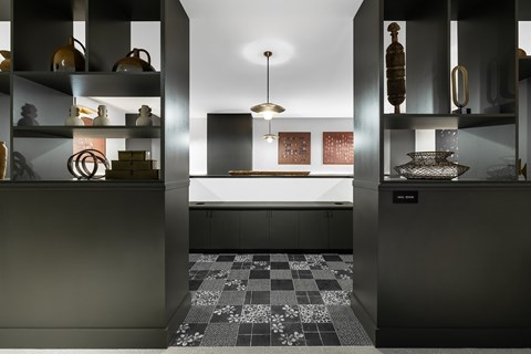 A modern kitchen with black cabinets and a checkered floor.