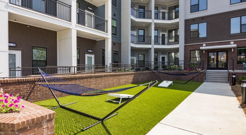 a rendering of a building with grass and benches