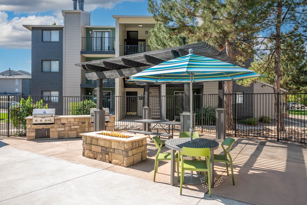 our apartments have a patio with a table and chairs and an umbrella
