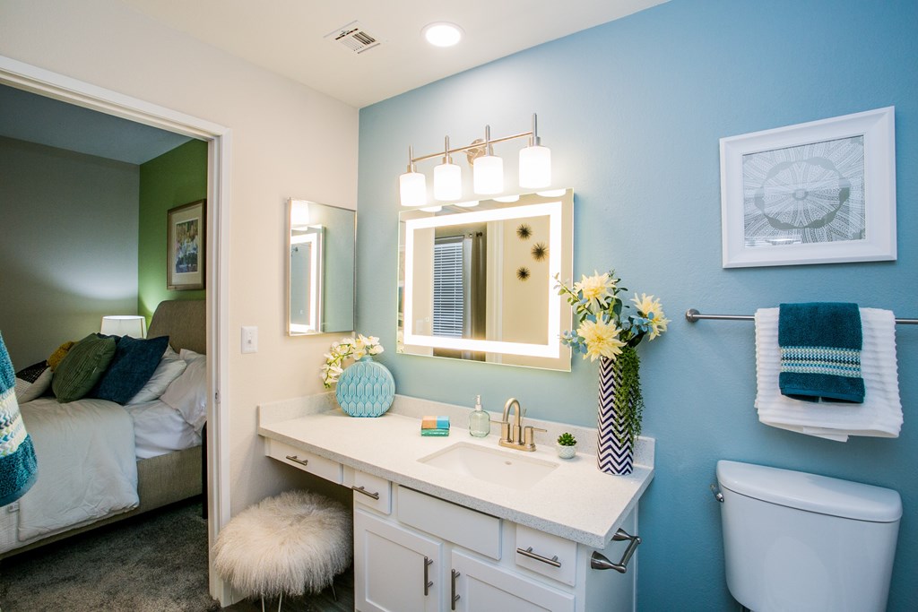A bathroom with a white vanity and a white toilet.
