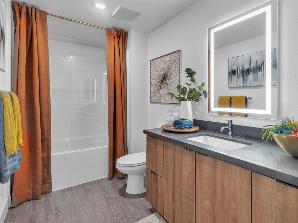 A bathroom with a toilet, sink, and shower.