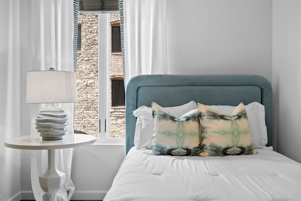 a bedroom with a bed and a table with a lamp