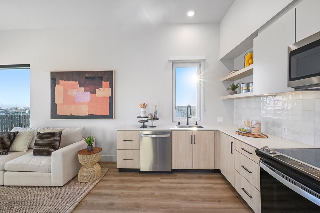 a living room with a couch and a kitchen with a sink