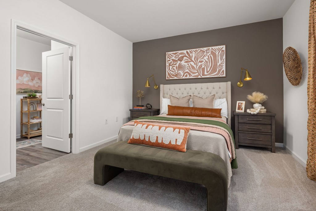 A bedroom with a bed, nightstand, and a painting on the wall.