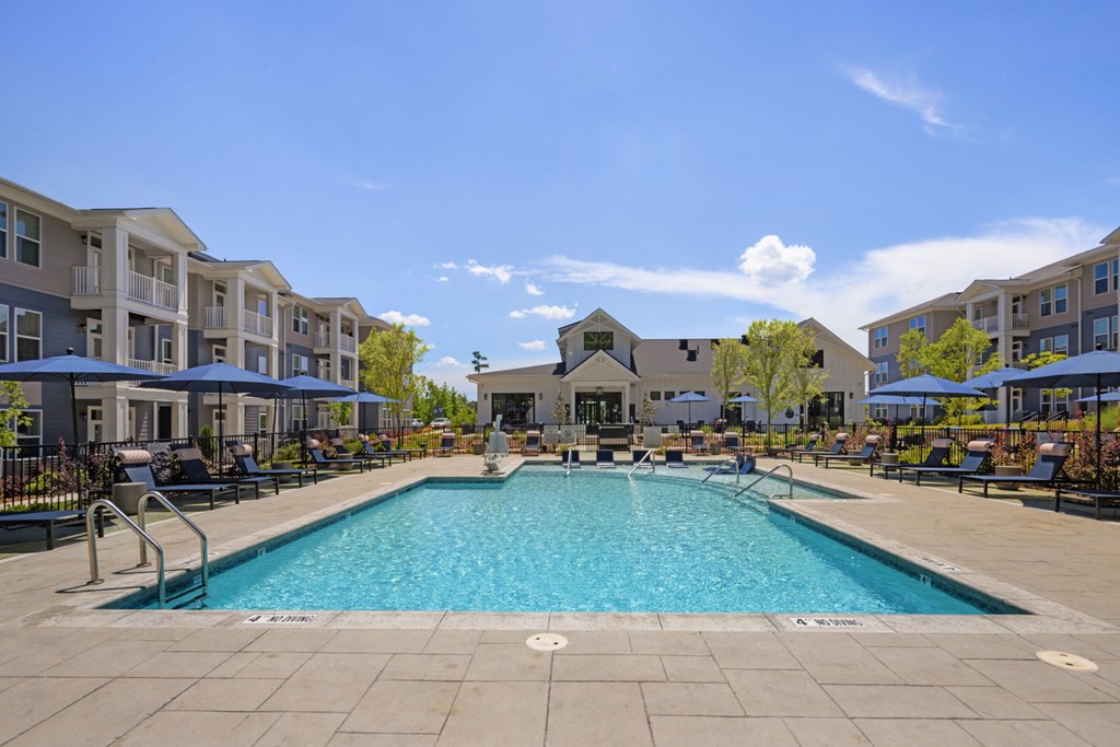A large swimming pool in the middle of a resort area.