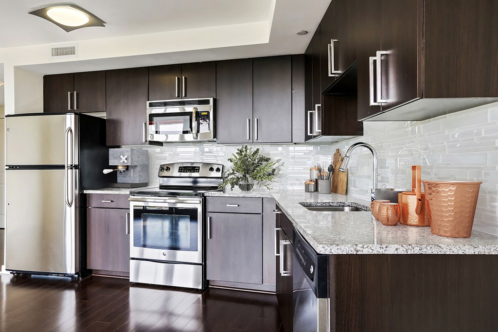 a modern kitchen with stainless steel appliances and marble counter tops