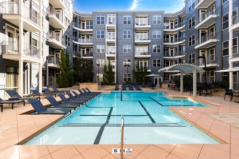 an apartment building with a swimming pool in front of it