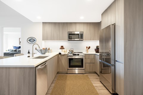 A modern kitchen with stainless steel appliances and wooden cabinets.