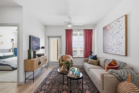 A living room with a couch, a side table, a rug, and a painting on the wall.