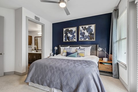A bedroom with a bed, nightstand, and a ceiling fan.