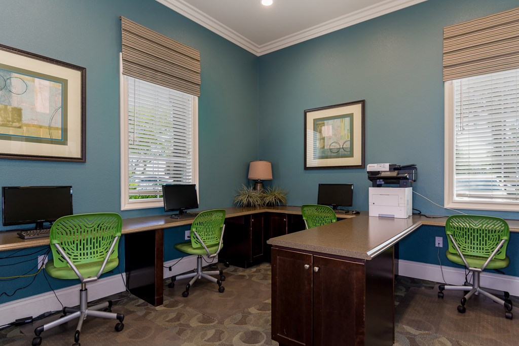 A room with blue walls and a desk with four chairs.