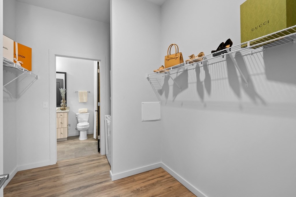 a walk in closet in a bedroom with a door to a bathroom