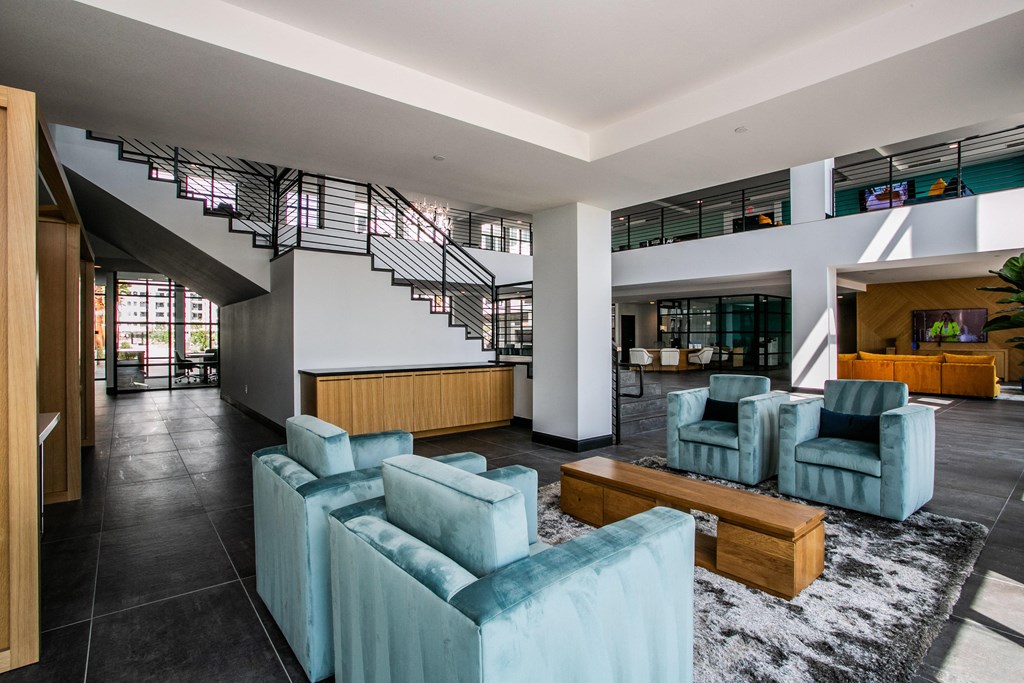 a living room with blue furniture and a staircase