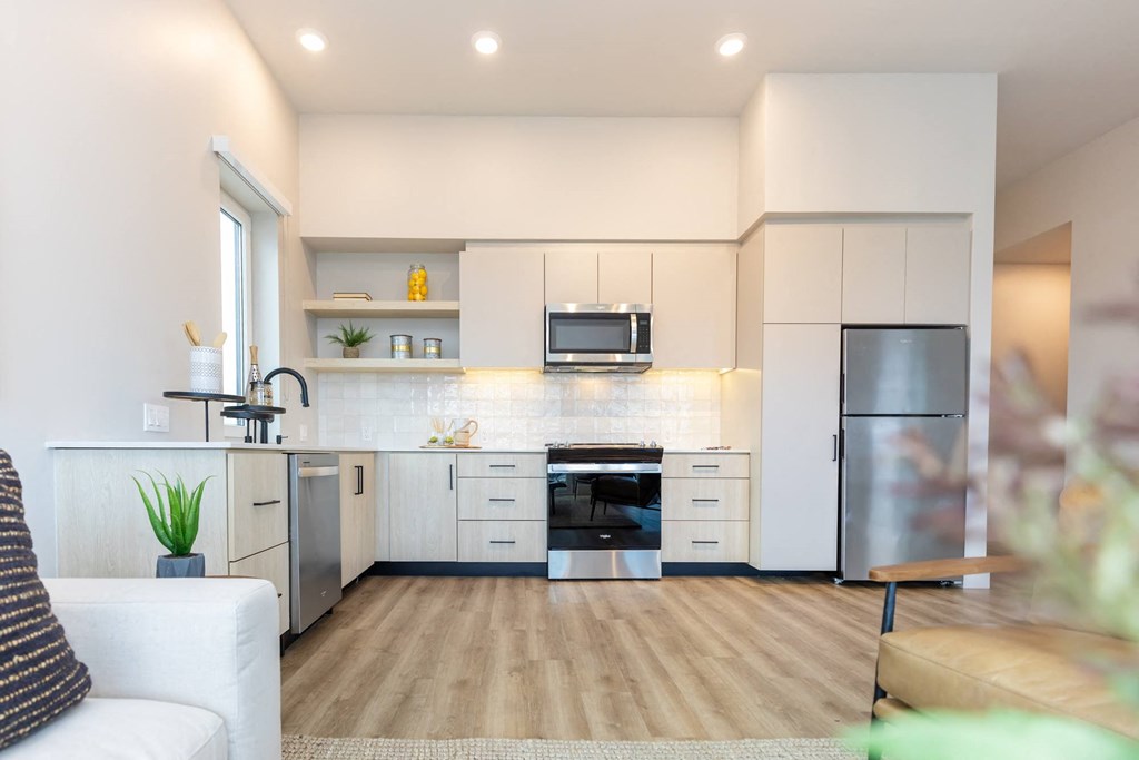 a kitchen with white cabinets and a stainless steel refrigerator