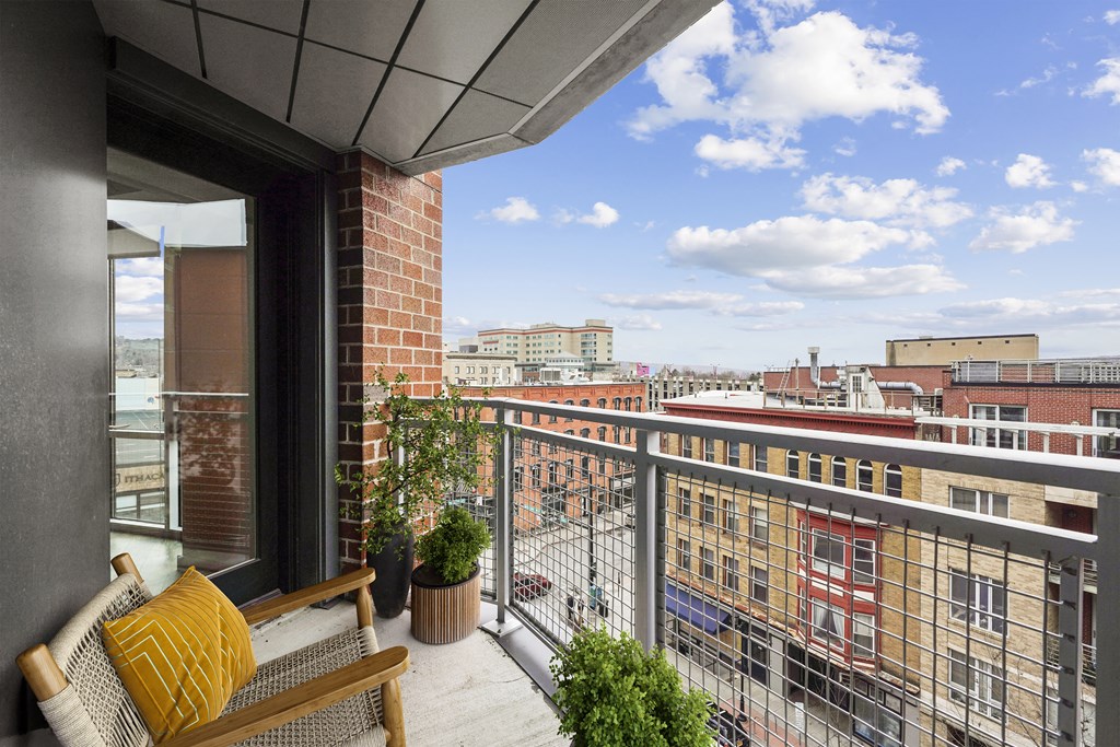 a balcony with a view of a city and a bench