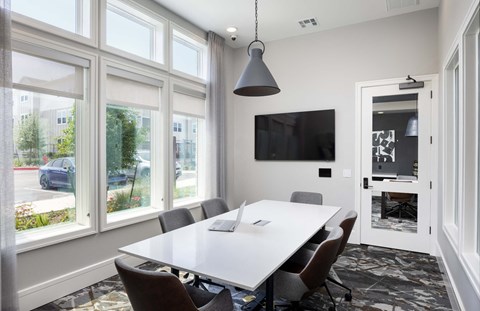 a conference room with large windows and a white table and chairs